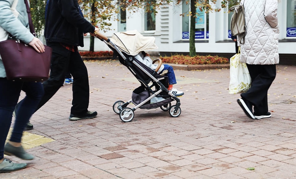 Ребенка везут в коляске.