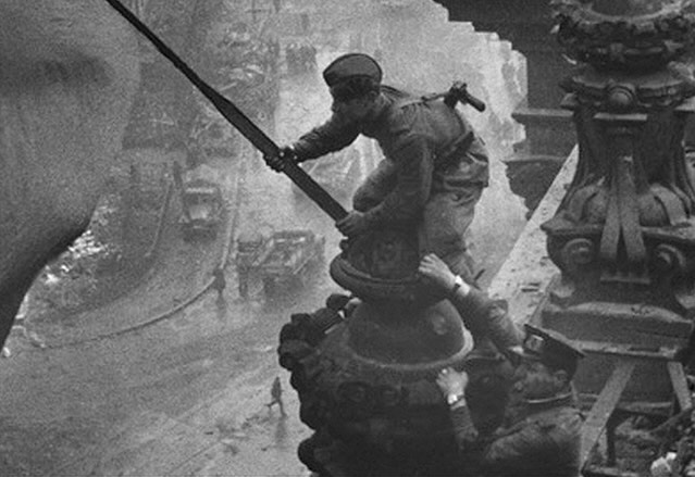 Оригинал фотографии с флагом и Рейхстагом. На фото можно заметить двое часов у солдата